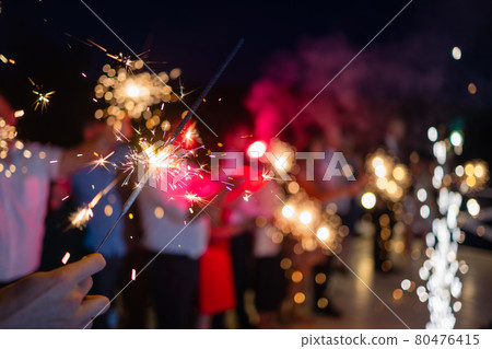 Picture showing group of friends having fun with sparklers. 80476415