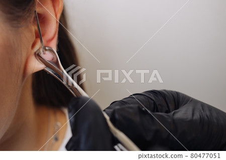 Professional holding the jewel of piercing just before screw the ball. Professional holding the jewel of piercing just before screw the ball. 80477051