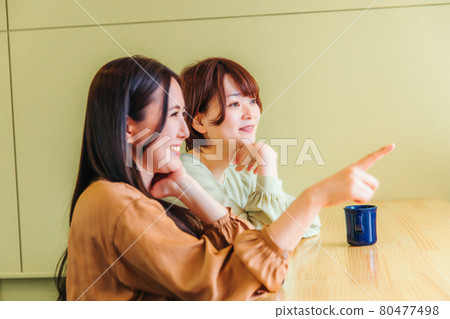 A girl friend who talks with friends at a cafe A girl friend who talks with friends at a cafe 80477498