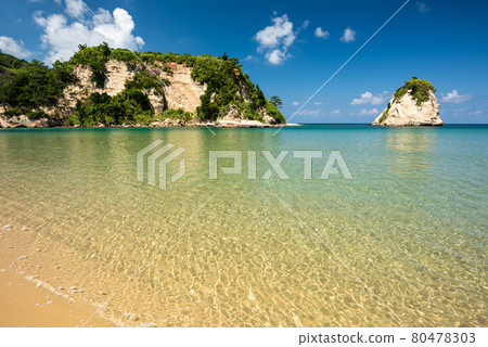Breathtaking view of an emerald green sea beach, coastal rocks, blue sky. Iriomote Island. 80478303