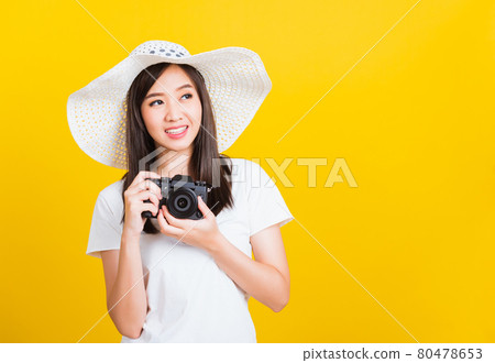 Woman photographer holding vintage digital mirrorless photo camera on hands 80478653