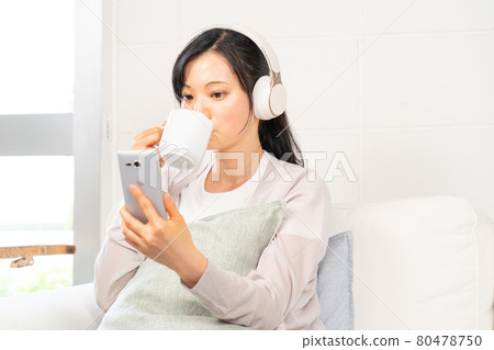 A woman who selects songs on her smartphone A woman who selects songs on her smartphone 80478750