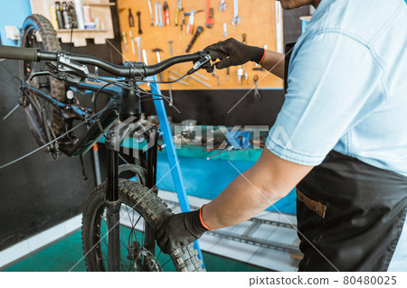 mechanical hands with gloves try the brake lever and hold the wheel to find out if the brakes are gripped 80480025