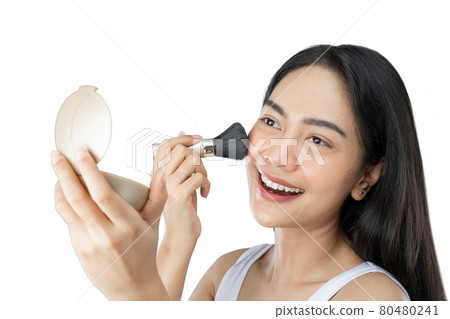 Beautiful young woman with long hair applying makeup using brush Beautiful young woman with long hair applying makeup using brush 80480241