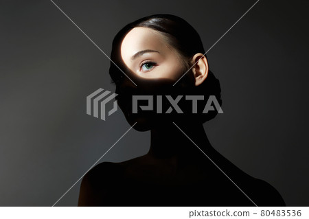 portrait of young woman with light on her face portrait of young woman with light on her face 80483536