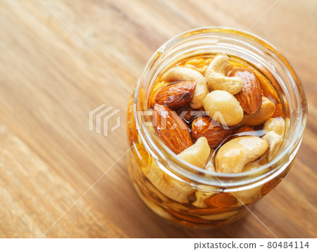 Honey pickled nuts in a glass jar 80484114