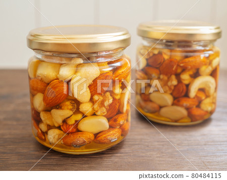 Honey pickled nuts in a glass jar Honey pickled nuts in a glass jar 80484115