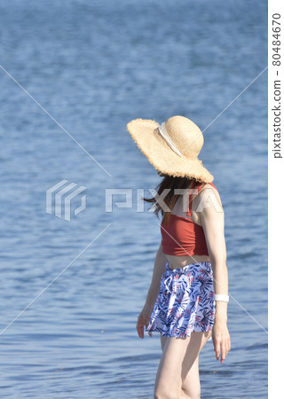 Taking a portrait of a woman in a swimsuit in a straw hat on the coast of Otobe-cho, Hokkaido in the summer Taking a portrait of a woman in a swimsuit in a straw hat on the coast of Otobe-cho, Hokkaido in the summer 80484670
