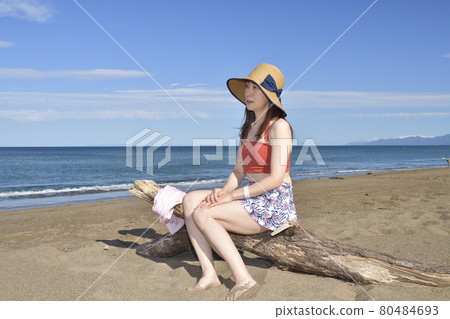 Taking a portrait of a woman in a swimsuit in a straw hat on the coast of Otobe-cho, Hokkaido in the summer Taking a portrait of a woman in a swimsuit in a straw hat on the coast of Otobe-cho, Hokkaido in the summer 80484693