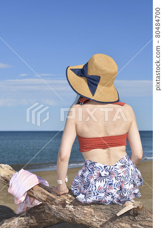 Taking a portrait of a woman in a swimsuit in a straw hat on the coast of Otobe-cho, Hokkaido in the summer 80484700
