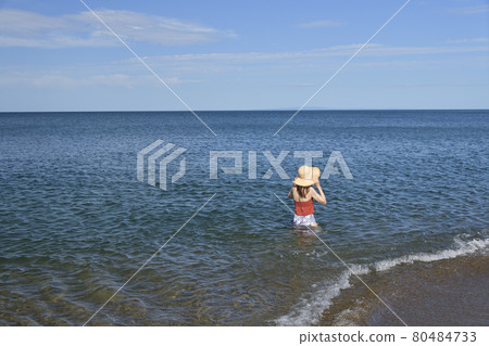 Taking a portrait of a woman in a swimsuit in a straw hat on the coast of Otobe-cho, Hokkaido in the summer 80484733