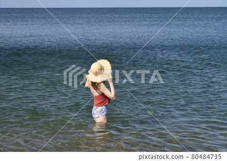 Taking a portrait of a woman in a swimsuit in a straw hat on the coast of Otobe-cho, Hokkaido in the summer 80484735