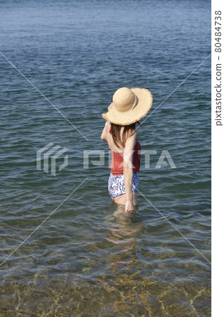 Taking a portrait of a woman in a swimsuit in a straw hat on the coast of Otobe-cho, Hokkaido in the summer 80484738