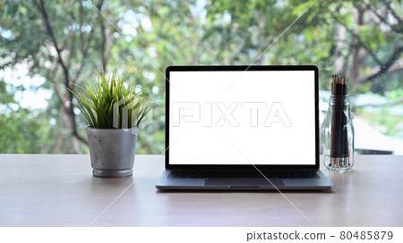 Computer laptop with blank display, houseplant and pencil holder on white table. Computer laptop with blank display, houseplant and pencil holder on white table. 80485879