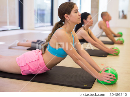 Four people lying in cobra pose with bender balls Four people lying in cobra pose with bender balls 80486240