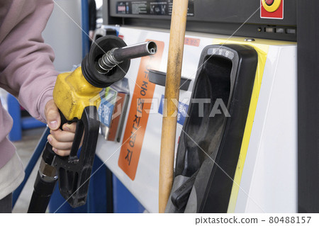 hand holding fuel nozzle at gas station 80488157