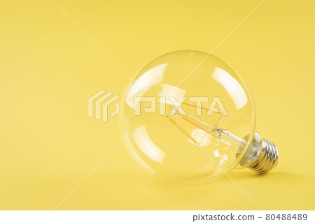 Transparent light bulb on yellow background 80488489