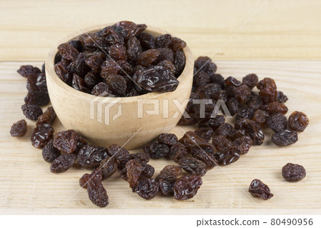 raisins in bowl on wooden table. raisins in bowl on wooden table. 80490956