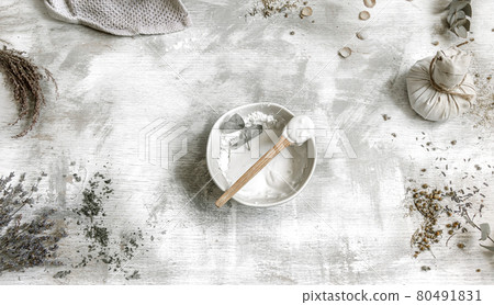Spa composition with a clay mask in a plate on a textured background. 80491831