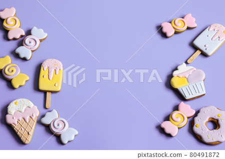 Colorful festive gingerbread cookies of different shapes covered with glaze. 80491872