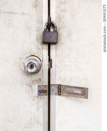 The old metal knob door and brass master key on the PVC door. 80491875