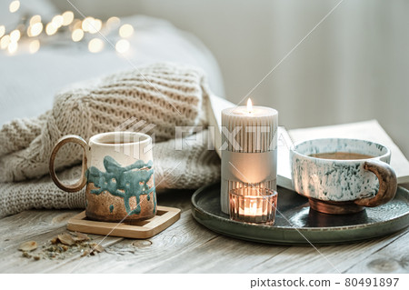 Cozy still life with ceramic cups with tea and a knitted element. Cozy still life with ceramic cups with tea and a knitted element. 80491897