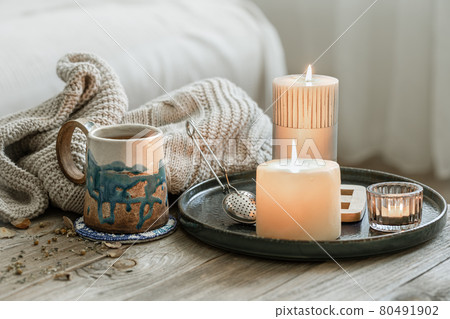Home still life with a cup of tea and burning candles. 80491902