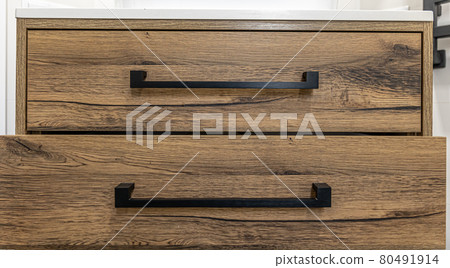 Close-up of modern dark wood furniture with black handles. 80491914