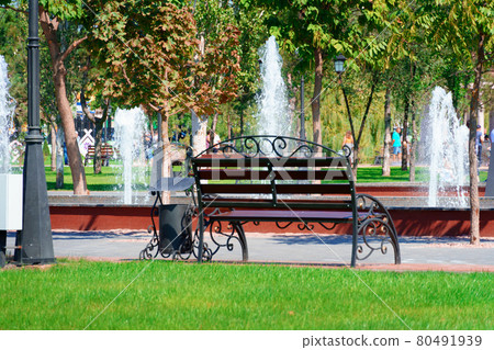 city park on a summer day, green lawns with grass and trees, path, benches and fountain, bright sunlight and shadows city park on a summer day, green lawns with grass and trees, path, benches and fountain, bright sunlight and shadows 80491939