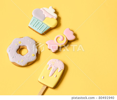 Colorful glazed gingerbread cookies on yellow background copy space. 80491940