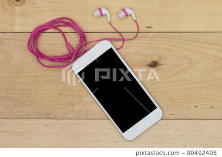 smartphone with headphones on the old wooden board 80492408