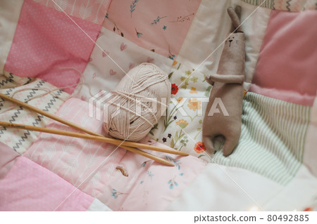 Cozy homely background with wool yarn and knitting needles on an armchair with a blanket. Cozy homely background with wool yarn and knitting needles on an armchair with a blanket. 80492885