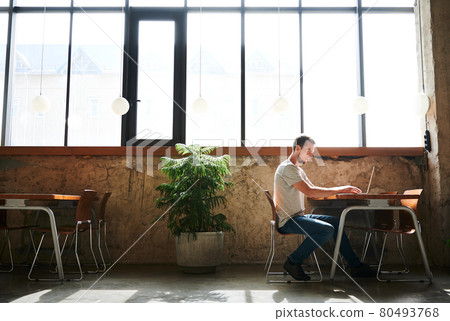 Man is working on laptop in cafe. Man is working on laptop in cafe. 80493768