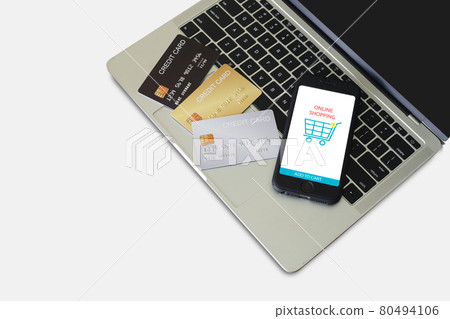 Smartphone with shopping application online in screen and a credit card on laptop computer. Smartphone with shopping application online in screen and a credit card on laptop computer. 80494106
