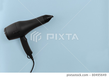 Black hair dryer on blue paper background 80495649