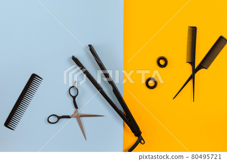 Various hair styling devices on the color blue, yellow paper background, top view Various hair styling devices on the color blue, yellow paper background, top view 80495721