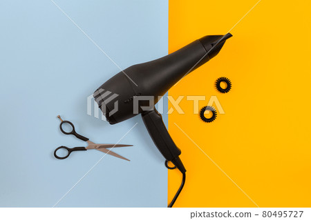 Styling hair with scissors, dryer and tools in barbershop on blue and yellow paper background top view mock-up 80495727