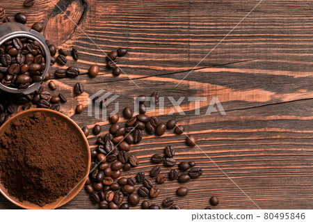 Coffee beans and ground coffee on rustic wooden table, view from 80495846