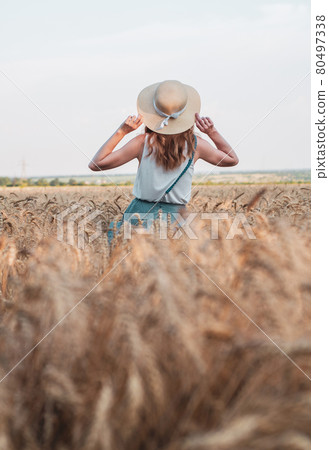 Happy woman with hat in summer field golden wheat, beautiful summer season. Girl enjoying life in colorful field ripe spikelets. Happy woman with hat in summer field golden wheat, beautiful summer season. Girl enjoying life in colorful field ripe spikelets. 80497338