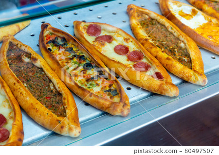 Traditional Turkish pide with various fillings on bakery showcase 80497507
