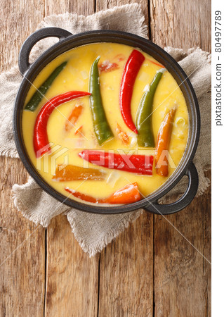 Ema datshi is among the most famous dishes in Bhutanese cuisine it is made from hot chili peppers and cheese closeup in the pan. Vertical top view 80497789