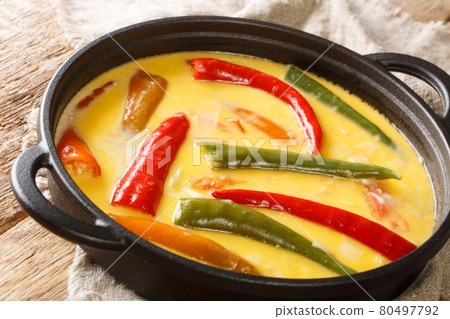 Spicy Ema datshi the national dish of Bhutan is an easy to make hearty soup with chilli peppers and cheese closeup in the pan. horizontal 80497792