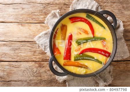 Spicy Ema datshi the national dish of Bhutan is an easy to make hearty soup with chilli peppers and cheese closeup in the pan. horizontal top view 80497798