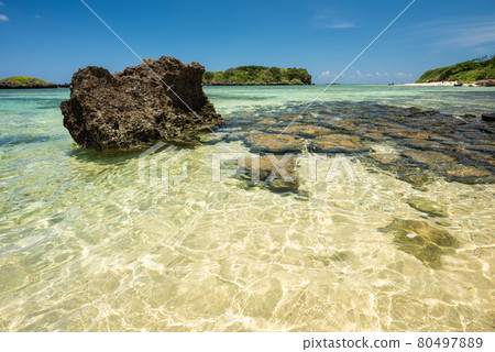 Gorgeous crystalline emerald green sea beach, coastal rocks, blue sky. Iriomote Island. Gorgeous crystalline emerald green sea beach, coastal rocks, blue sky. Iriomote Island. 80497889