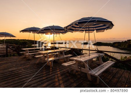 Parasol and benches on wooden deck at sunset. Iriomote Island. 80497890