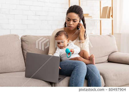 Mother Caring For Baby Talking On Phone Using Laptop Indoor 80497904
