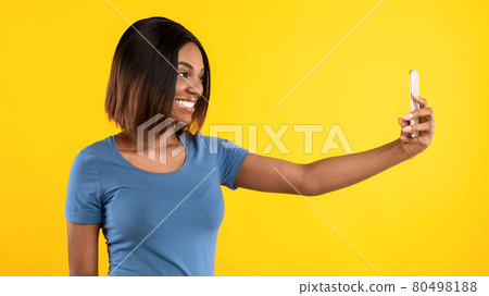 Cheerful Black Female Making Selfie On Smartphone Over Yellow Background 80498188