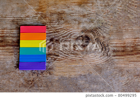 Close up of LGBT flag against the light wooden background. LGBT rainbow colors from plasticine Close up of LGBT flag against the light wooden background. LGBT rainbow colors from plasticine 80499295