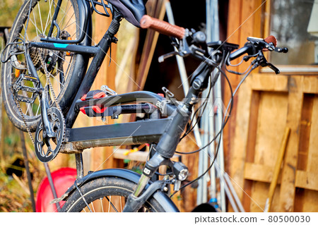Black bike hanging at an angle on a bike repair and maintenance assembly stand 80500030