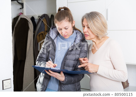 Mature woman answers questions of the interviewer at home Mature woman answers questions of the interviewer at home 80500115